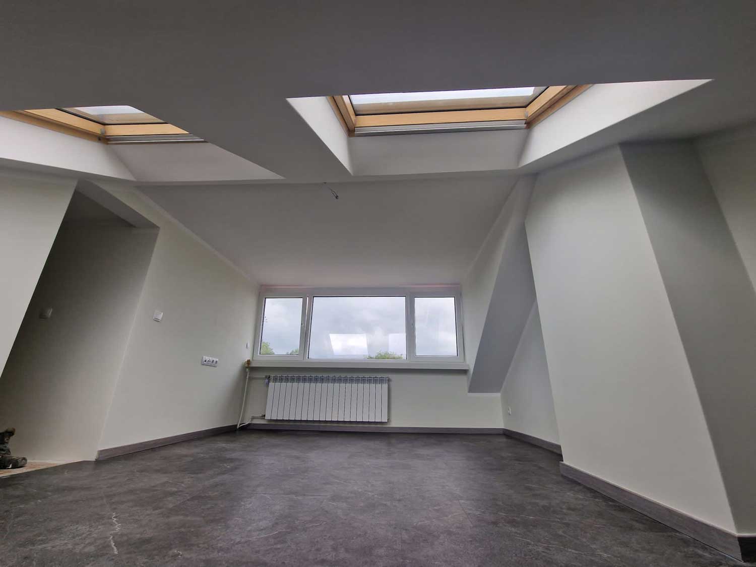 Afgewerkte zolderkamer met dakramen en strak stucwerk