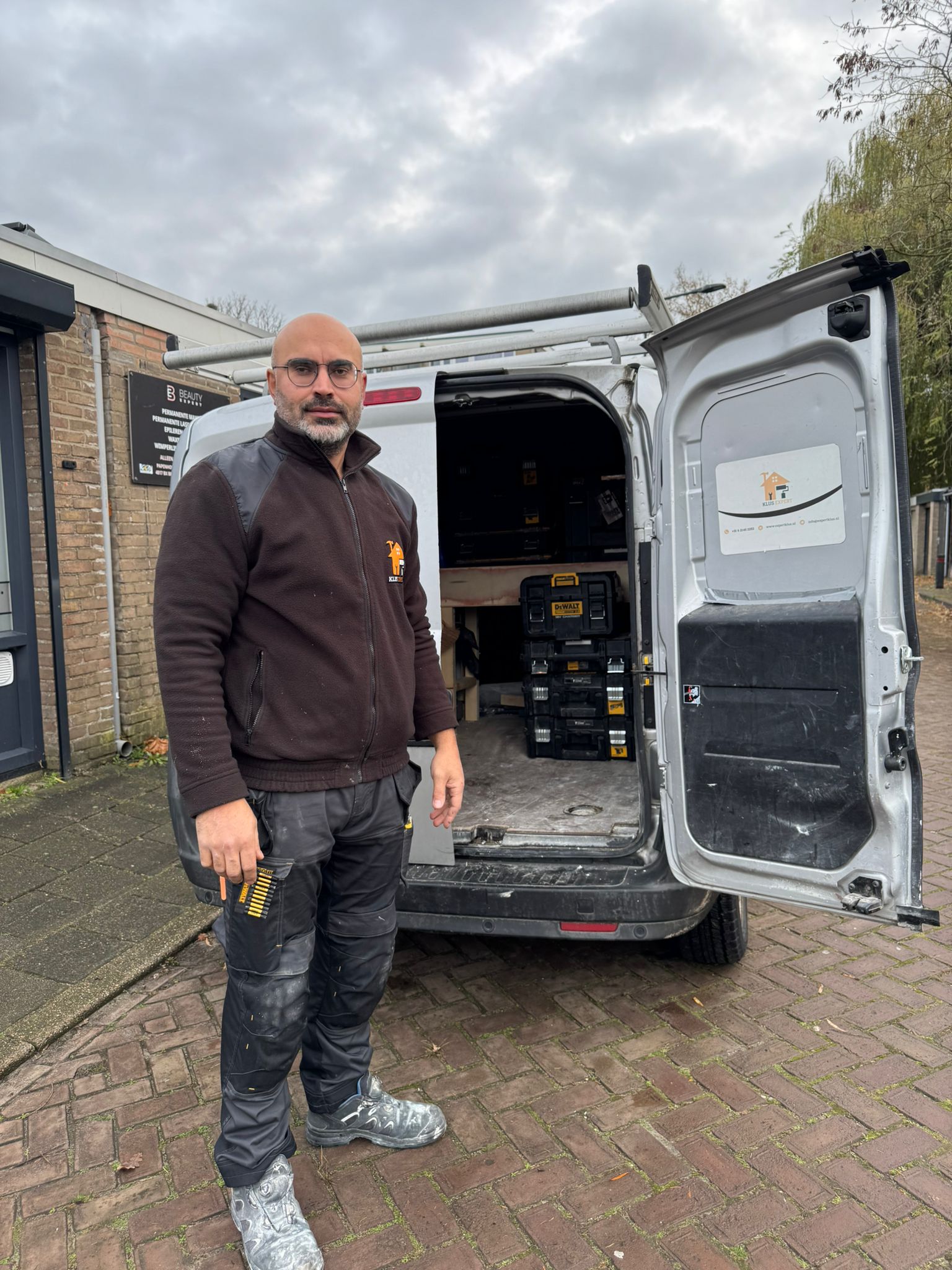 Vakman van Klus Expert bij zijn bedrijfsbus in Breda